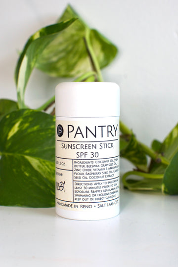 Sunscreen stick with 'Pantry' branding on a white background with green leaves.